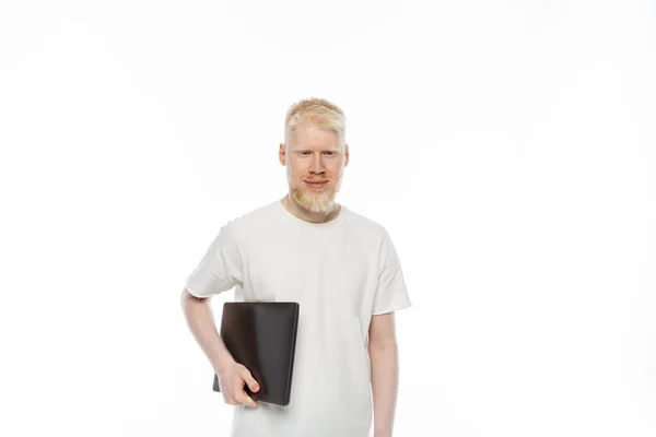 Homem freelancer albino feliz em t-shirt segurando laptop isolado em branco — Fotografia de Stock