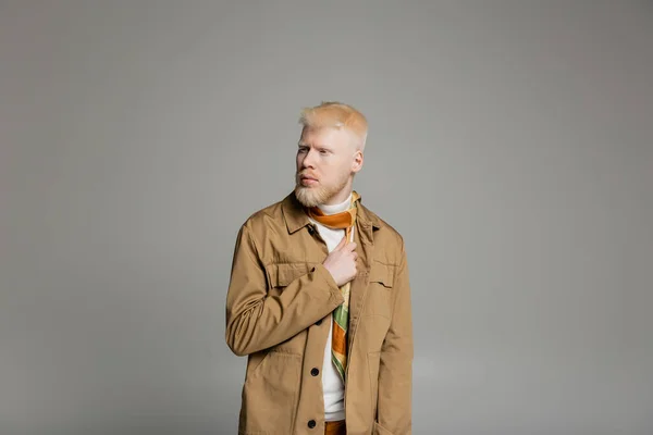 Bearded albino man in stylish shirt jacket and silk scarf posing isolated on grey — Stock Photo