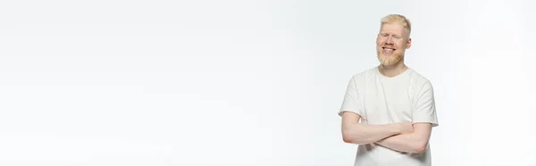 Bearded albino man in t-shirt smiling and standing with crossed arms isolated on white, banner — Stock Photo