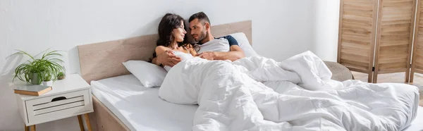 Young man hugging girlfriend on bed in morning, banner — Stockfoto