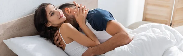 Man kissing positive girlfriend on bed at home, banner — Stock Photo