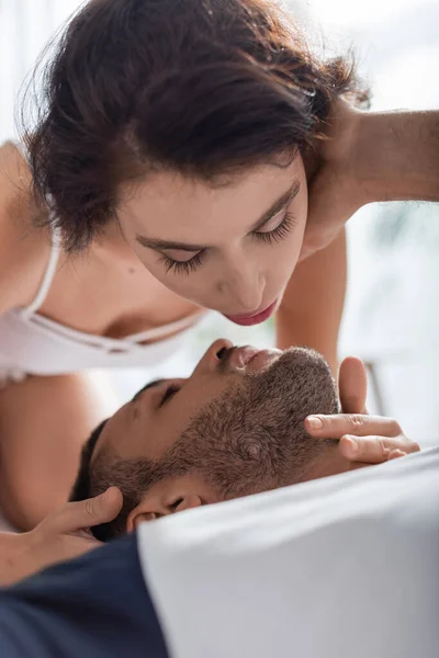 Sexy femme touchant petit ami barbu sur le lit — Photo de stock