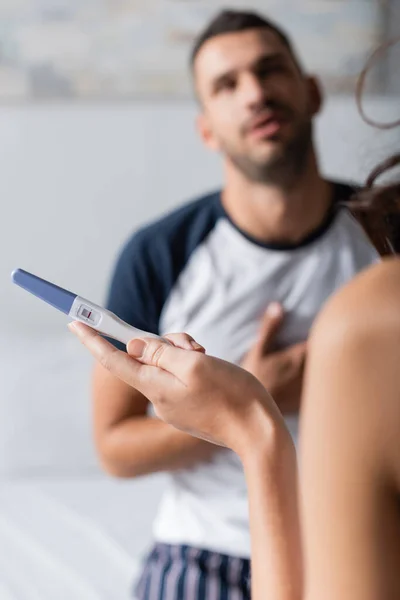 Frau mit negativem Schwangerschaftstest bei verschwommenem Freund zu Hause — Stockfoto