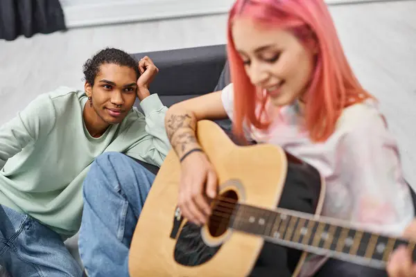 Focus on loving handsome african american man looking at his blurred girlfriend playing guitar — Stock Photo
