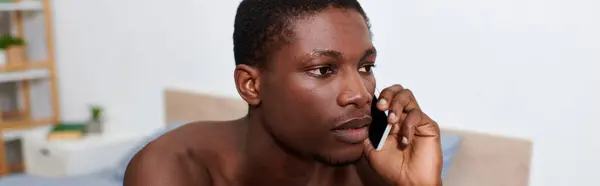 African American man, shirtless, talking on cell phone. — Stock Photo