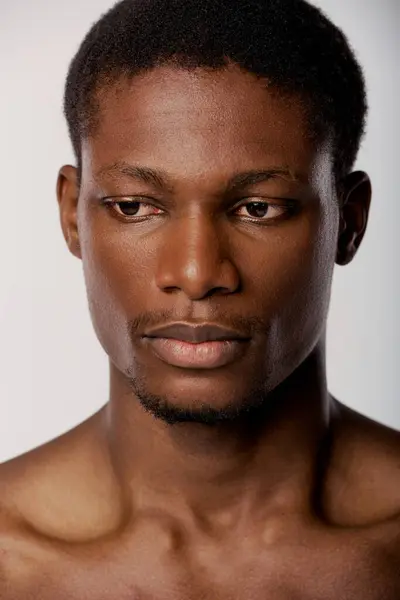 Um close-up de um homem afro-americano em um estúdio branco, com foco em seu rosto — Fotografia de Stock