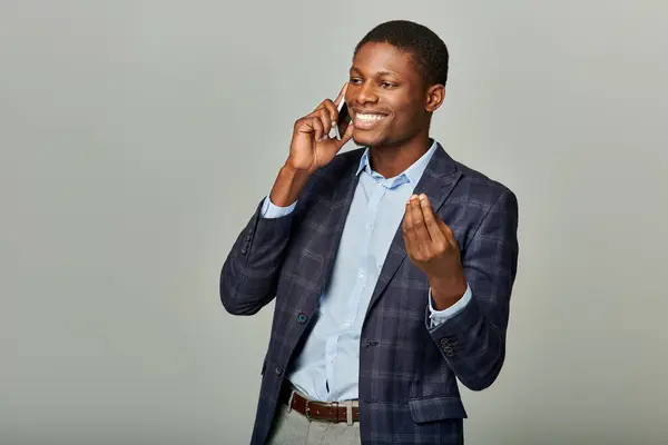 African American businessman in checkered blazer conversing on mobile phone, exuding professionalism and focus. — Stock Photo