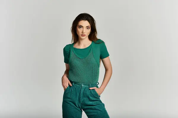 A young woman poses confidently in a green ensemble. — Stock Photo