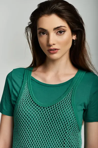 A young woman poses in a stylish green mesh top. — Stock Photo