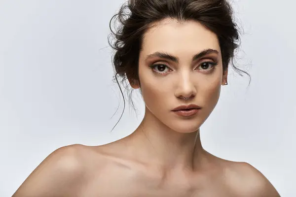Giovane donna con uno sguardo penetrante, piercing al setto, e sottile orecchino fissa lo spettatore. — Foto stock