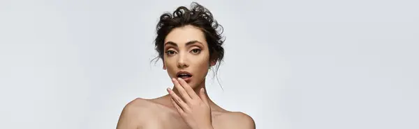 A young woman in elegant attire, with a hand covering her mouth, appears surprised. — Stock Photo