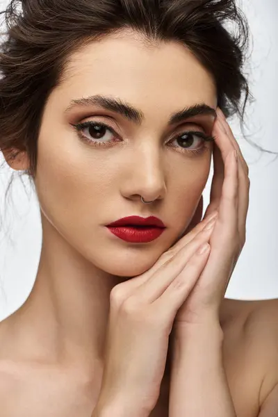A close-up portrait of a young woman with red lipstick and her hands resting on her face. — Stock Photo