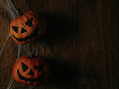 Ahşap masa arkasında Cadılar Bayramı balkabağı