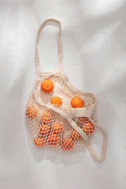 Kumaş çanta beyaz arka planda taze mandalina
