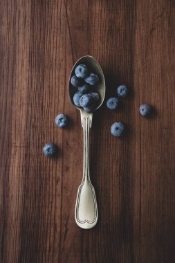 Böğürtlen ve tahta bir masada kaşık.