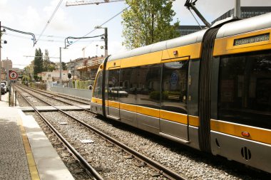 Bu görüntü Porto metro istasyonunda Porto, Portekiz 'in modern ve verimli toplu taşıma sistemini gösteren bir tramvayı yakalar. Şehir sahnesi, şehrin sürdürülebilir olmaya olan bağlılığını somutlaştıran elektrik tramvay ve tren raylarını vurguluyor.