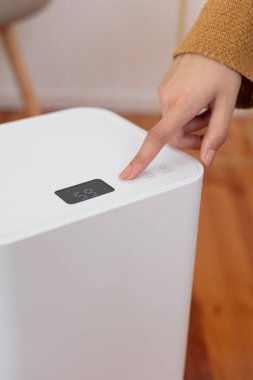 Pürüzsüz ve modern bir nemlendirici dijital ekran ile bir ev ortamında sergileniyor. Bir kişinin parmağı dokunmatik kontrole basarken görülüyor, kullanıcı dostu arayüzünü vurguluyor ve kapalı alanda daha sağlıklı bir ortam için etkili nem kontrolü yapıyor..