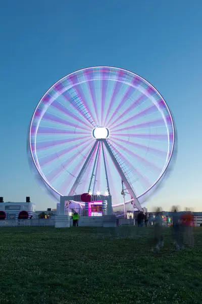 stock image A stunning long exposure shot of a brightly lit Ferris wheel at Rock in Rio Lisboa 2024. The vibrant lights and motion blur create a mesmerizing effect, capturing the festive atmosphere of the night.