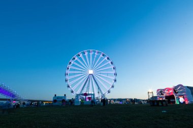 Rio Lisboa 2024 'teki Rock' ta parlak bir dönme dolabın çarpıcı uzun pozu. Canlı ışıklar ve hareket bulanıklığı büyüleyici bir etki yaratarak gecenin şenlikli atmosferini yakalıyor..