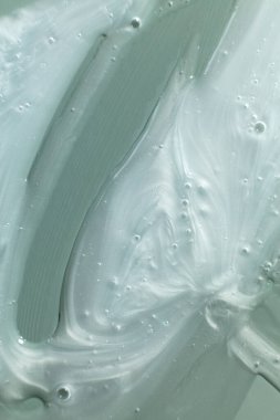 Nemlendiricinin dokusunun makro görüntüsü pürüzsüz, parlak yüzeyini görünür kıvrımlar ve kabarcıklarla gösteriyor. Bu detaylı yakın çekim ürünün kremsi ve sulandırıcı özelliklerini vurguluyor