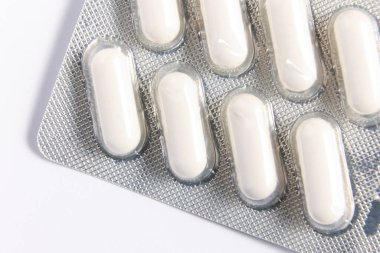 İçinde beyaz haplar olan su toplayan bir pakete yakından bakın. Bu yüksek çözünürlüklü görüntü, sağlık ürünleri, eczacılık ve tıbbi malzemelerin sergilenmesi için idealdir, eczane ve sağlıkla ilgili konular için mükemmeldir..