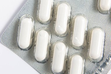 İçinde beyaz haplar olan su toplayan bir pakete yakından bakın. Bu yüksek çözünürlüklü görüntü, sağlık ürünleri, eczacılık ve tıbbi malzemelerin sergilenmesi için idealdir, eczane ve sağlıkla ilgili konular için mükemmeldir..