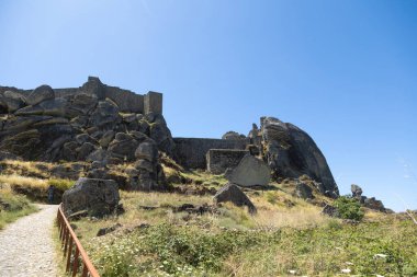Portekiz 'de kayalık bir tepenin tepesine tünemiş Monsanto Kalesi etkileyici ortaçağ mimarisi ve taş tahkimatlarını sergiliyor. Büyük kayalarla çevrili antik kalıntılar kırsal kesimin çarpıcı bir panoramik manzarasını sunuyor..