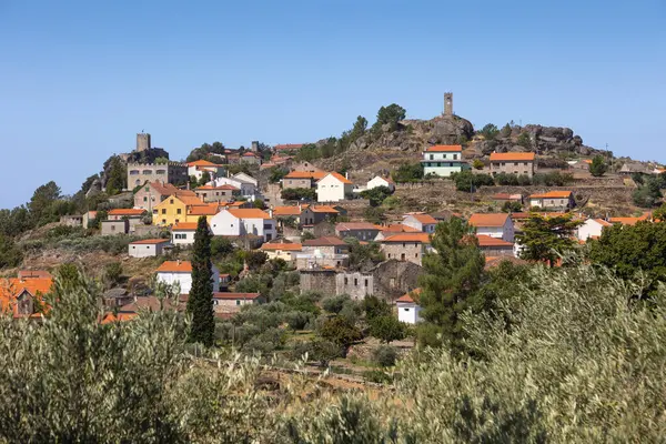 Stock image  A picturesque view of the historic village of Sortelha, Portugal, featuring stone houses and ancient fortress walls under a bright blue sky. This charming medieval village is a perfect example of Portuguese cultural heritage.