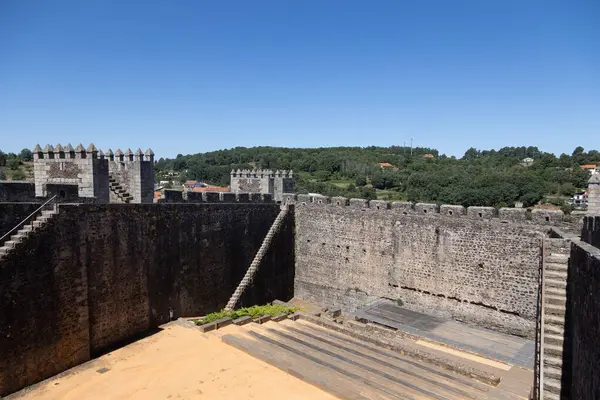 stock image Sabugal Castle in Portugal features imposing stone walls and a historic stone staircase, showcasing its medieval architecture. The image captures the fortress under a clear blue sky