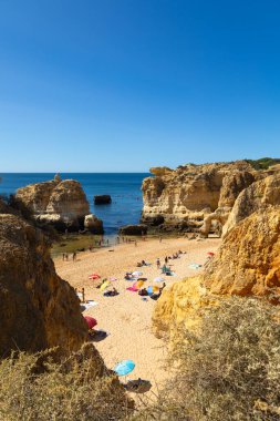 Albufeira, Algarve, Portekiz 'deki So Rafael Sahili' nin göz kamaştırıcı manzarası. Altın kum, berrak mavi sular ve dramatik uçurumlar. Sahilde sakin bir yaz tatili için mükemmel bir yer..