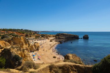 Albufeira, Algarve, Portekiz 'deki So Rafael Sahili' nin göz kamaştırıcı manzarası. Altın kum, berrak mavi sular ve dramatik uçurumlar. Sahilde sakin bir yaz tatili için mükemmel bir yer..