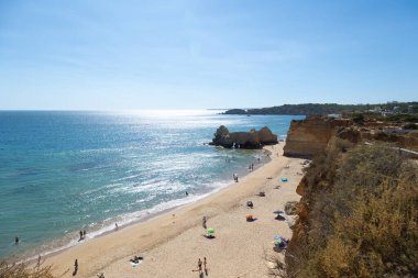 Praia da Rocha in Portimo, Algarve, Portugal, offers golden sands, clear blue waters, and stunning rock formations. A popular tourist destination for sunbathing, swimming, and seaside activities. clipart