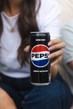 Close-up of a woman's hand holding a can of Pepsi Zero Sugar, focusing on the Pepsi logo and the product's branding. The image conveys a casual and refreshing moment with a modern appeal. clipart