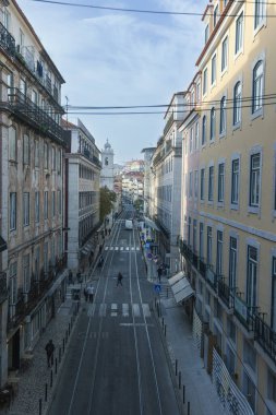 Lizbon caddesinde, yumuşak sabah ışığı altında tarihi pastel renkli binalarla çevrili tramvay rayları sergileniyor. Bu canlı şehir manzarası Portekiz 'in başkentinin cazibesini yakalıyor..