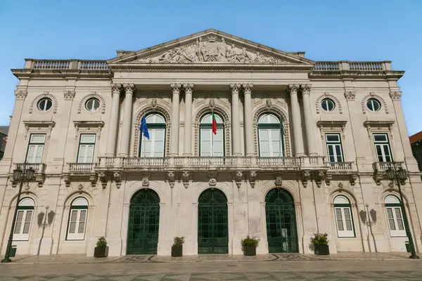 Lizbon Belediyesi 'nin (Cmara Belediyesi de Lisboa) klasik mimari, Portekiz ve AB bayraklarıyla berrak mavi bir gökyüzü altında ön manzarası. Lizbon 'un kalbinde tarihi bir dönüm noktası.