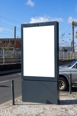 Lizbon 'un modern kentsel bölgesinde boş bir reklam panosu duruyor. Çağdaş mimari ile çevrelenmiş olan bu temiz ve boş ekran, promosyon modelleri veya kentsel tasarım projeleri için idealdir..
