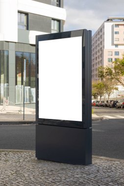 Lizbon 'un modern kentsel bölgesinde boş bir reklam panosu duruyor. Çağdaş mimari ile çevrelenmiş olan bu temiz ve boş ekran, promosyon modelleri veya kentsel tasarım projeleri için idealdir..