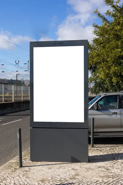 Lizbon 'un modern kentsel bölgesinde boş bir reklam panosu duruyor. Çağdaş mimari ile çevrelenmiş olan bu temiz ve boş ekran, promosyon modelleri veya kentsel tasarım projeleri için idealdir..