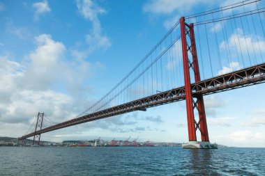 Lisbon, bu çarpıcı fotoğraf Tagus Nehri üzerinde uzanan 25 de Abril Köprüsü 'nü gösteriyor. Canlı mavi gökyüzü altında kentsel mimariyle doğal güzelliği harmanlıyor..