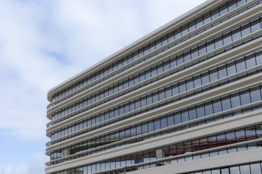 Lizbon, Portekiz 'de gösterişli, modern bir ofis binası, temiz mimari çizgiler, cam cephe ve minimalist tasarım sergiler, mavi gökyüzünü ve kentsel karmaşıklığı yansıtır..