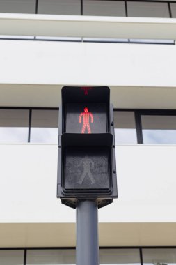 Lizbon, Portekiz 'de kırmızı yaya trafik ışığı, modern beyaz mimarinin arka planına karşı durduğunu gösteriyor. Şehir sokak sahnesi güvenlik, altyapı ve çağdaş şehir yaşamını vurguluyor.