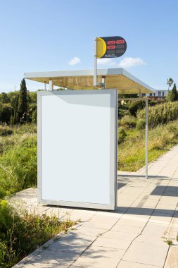 Portekiz 'de modern cam bir otobüs durağında boş bir reklam panosu, güneşli bir günde çekilmiş, temiz hatlar ve halka açık, sakin bir banliyö arkaplanı sunuyor..