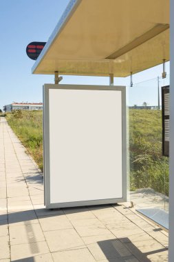 Portekiz kentsel mahallesinde boş bir reklam paneli olan modern bir otobüs durağı, gün ışığında yıkanmış. Temiz, yapılandırılmış hatlar doğal ve yerleşik elementlerle tezat oluşturuyor..