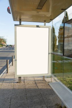 Portekiz 'de çekilen bu modern cam otobüs durağında reklam için hazır boş bir reklam panosu, temiz şehir hatları ve doğal gün ışığı ile görsel promosyon için mükemmel bir yer sunuyor..