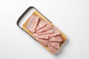 Siyah saplı ahşap bir tahtanın üzerinde titizlikle katlanmış jambon dilimleri, beyaz bir arka plana karşı dizilmiş, temiz, minimal ve gurme tarzı bir yemek sunumu sergiliyor..
