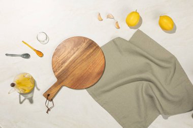 Asgari mutfak dairesi, ahşap kesim tahtası, limon, sarımsak, zeytinyağı ve taş bir yüzeyde kap kacak ile yatıyordu. Doğal ışık ve kırsal tonlar sıcak, Akdeniz yemek atmosferi yaratır..