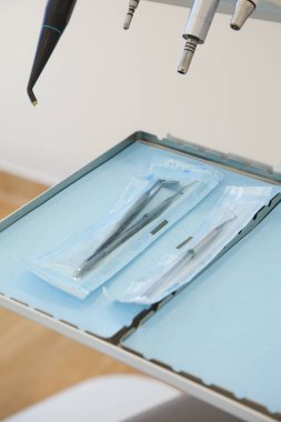Lizbon, Portekiz 'de modern bir diş kliniğinde plastik keseye kapatılmış steril diş aletleri. Temiz, profesyonel kurulum hijyen, hazırlık ve sağlık standartlarını vurguluyor.