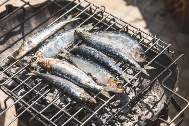 Geleneksel kömür mangalında kızartılan taze sardalyalar. Balıklar hafif kömürleşmiş ve cızırdıyor, Akdeniz mutfağının ve açık hava yemeklerinin özünü yakalıyorlar. Portekiz