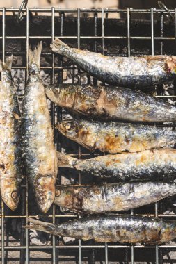 Geleneksel kömür mangalında kızartılan taze sardalyalar. Balıklar hafif kömürleşmiş ve cızırdıyor, Akdeniz mutfağının ve açık hava yemeklerinin özünü yakalıyorlar. Portekiz