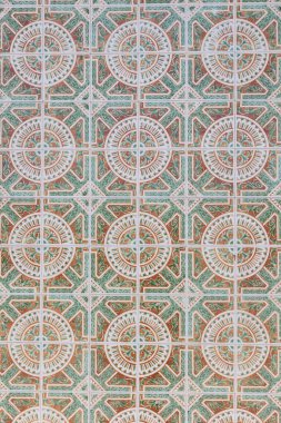 Yeşil ve terracotta tonlarında dairesel ve geometrik desenlere sahip klasik Portekiz fayansları, simetrik ve zengin detaylı bir kompozisyonda geleneksel işçilik ve süsleme tasarımı sergiliyor.